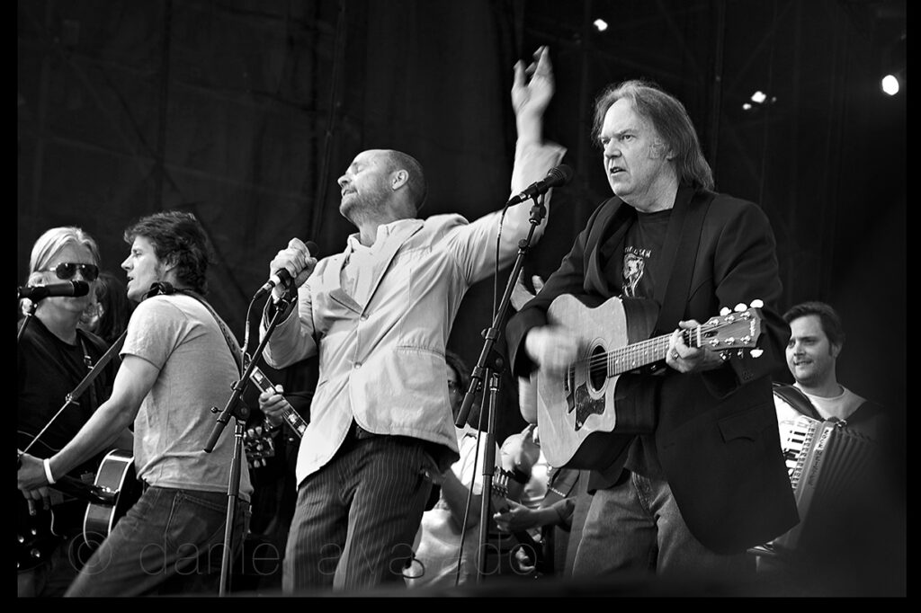 Neil Young, Gord Downie, and Cowboy Junkies performing 'Keep On Rockin' in the Free World' during the Live 8 World Finale at Molson Park on July 2, 2005. Photo by Daniel Alvarado.